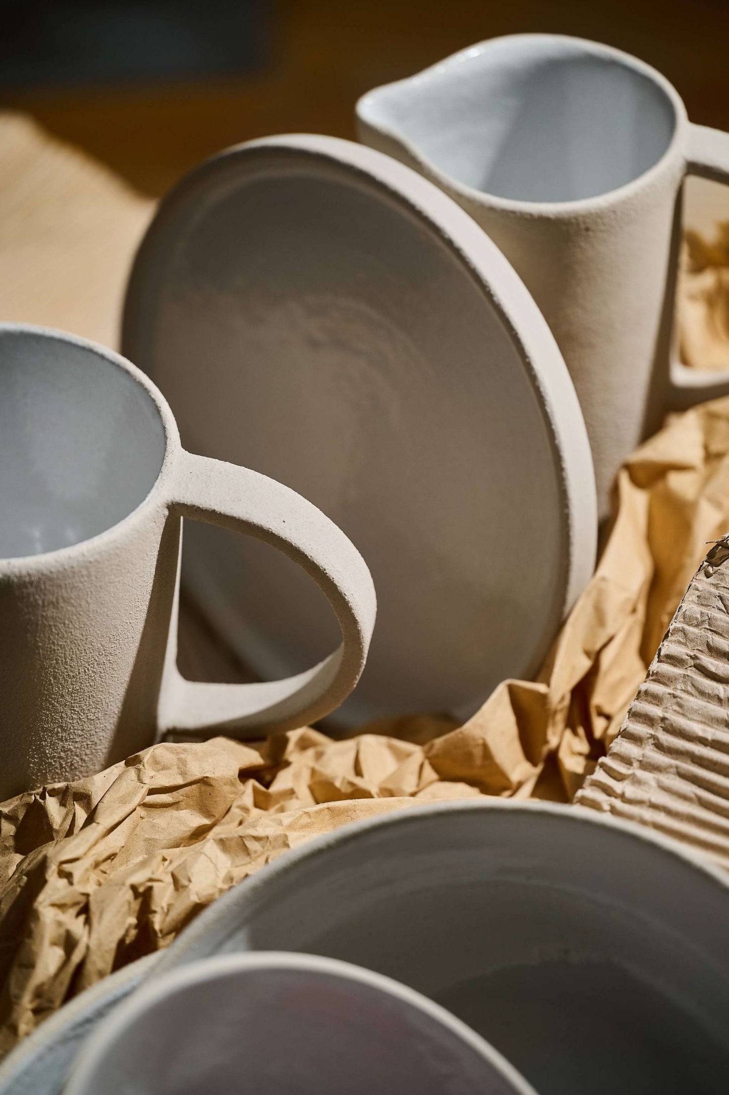 Handmade stoneware pitcher with rough exterior and white glazed interior, classic shape, made in Ukraine