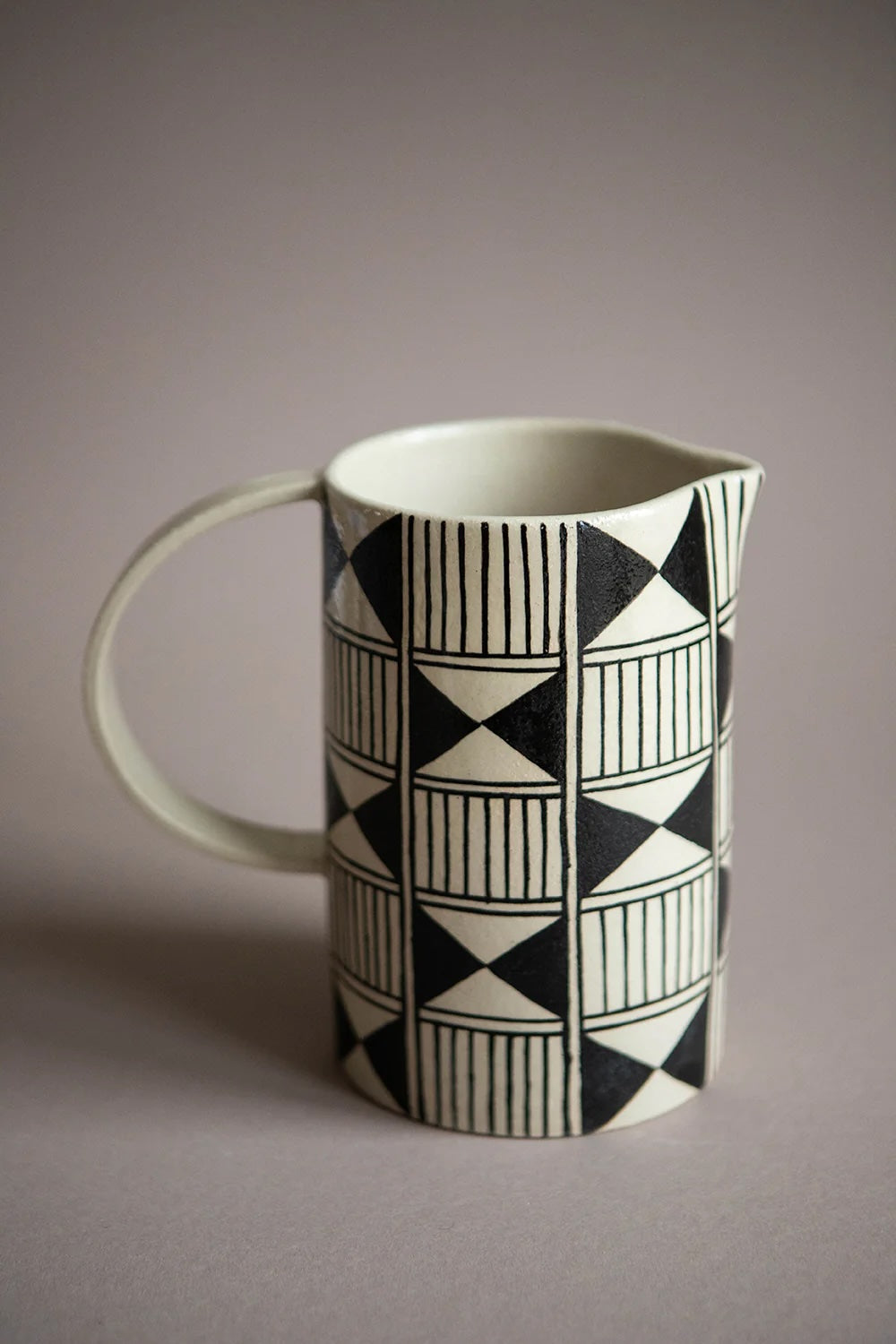 Handmade ceramic heritage pitcher with black geometric pattern on textured stoneware, 32 oz artisanal serving carafe