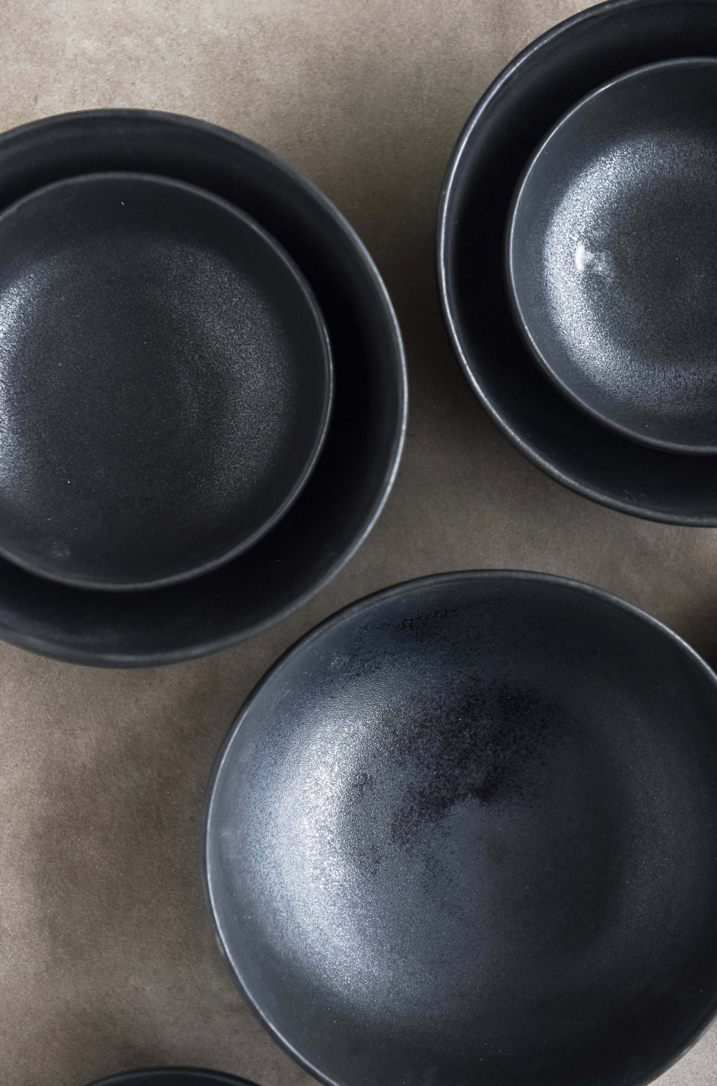 Black matte stoneware bowl with organic curves and lighter rim, handmade in Ukraine