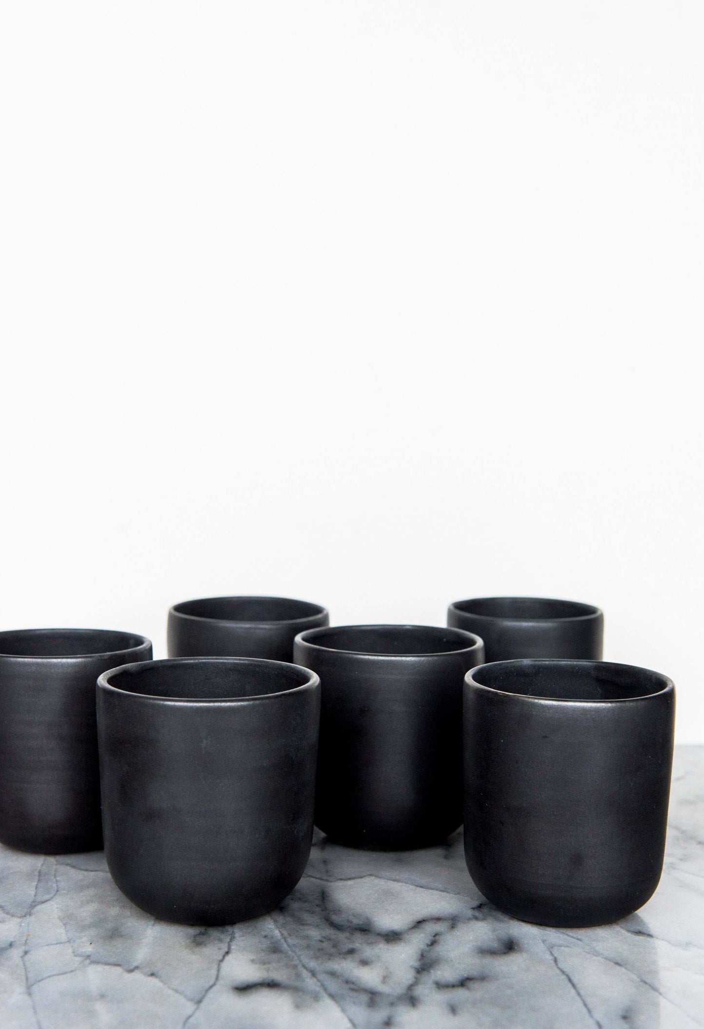 Black matte handmade stoneware cup with organic edges for coffee and tea