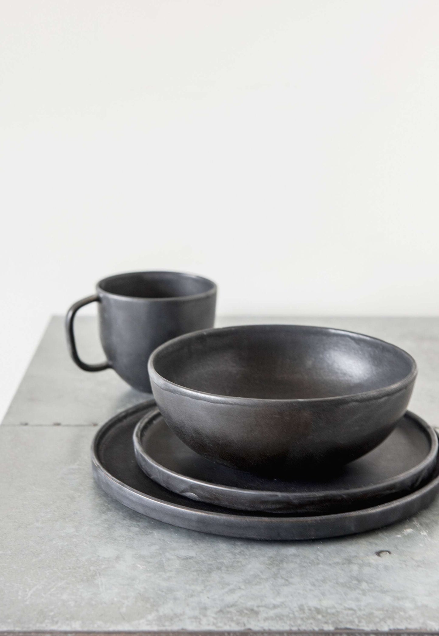 Black matte stoneware coffee mug with reactive glaze and ergonomic handle