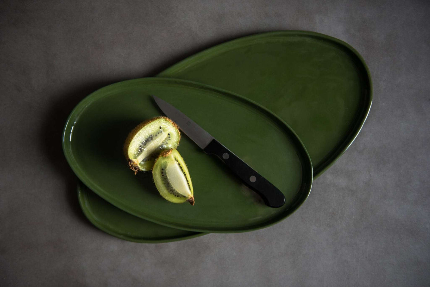 Handmade green oval porcelain platter with organic rounded edges for elegant serving