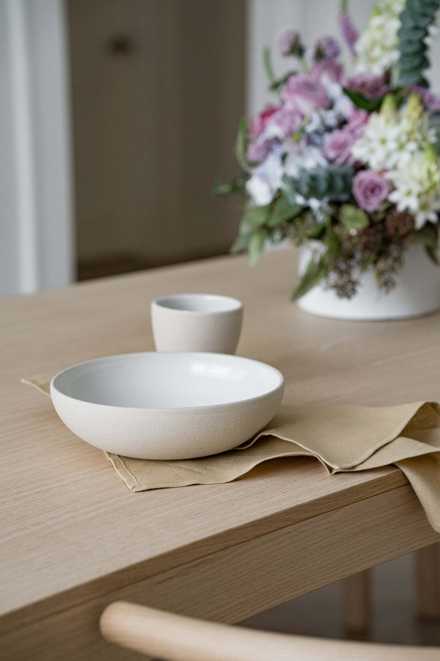 Handmade stoneware coffee cup with rough exterior and white glazed interior, crafted in Ukraine