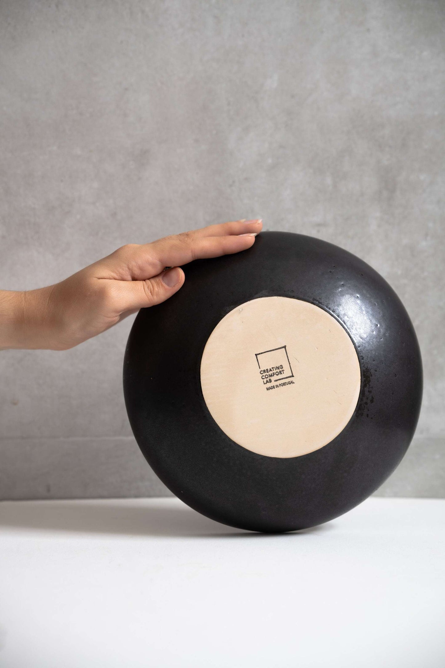 Matte black stoneware pasta bowl with high sides and reactive glaze pattern, made in Portugal