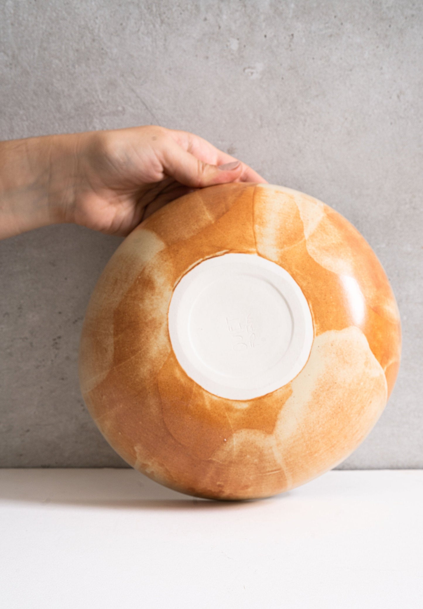 Beige matte stoneware salad serving bowl with unique reactive glaze and rust color strokes