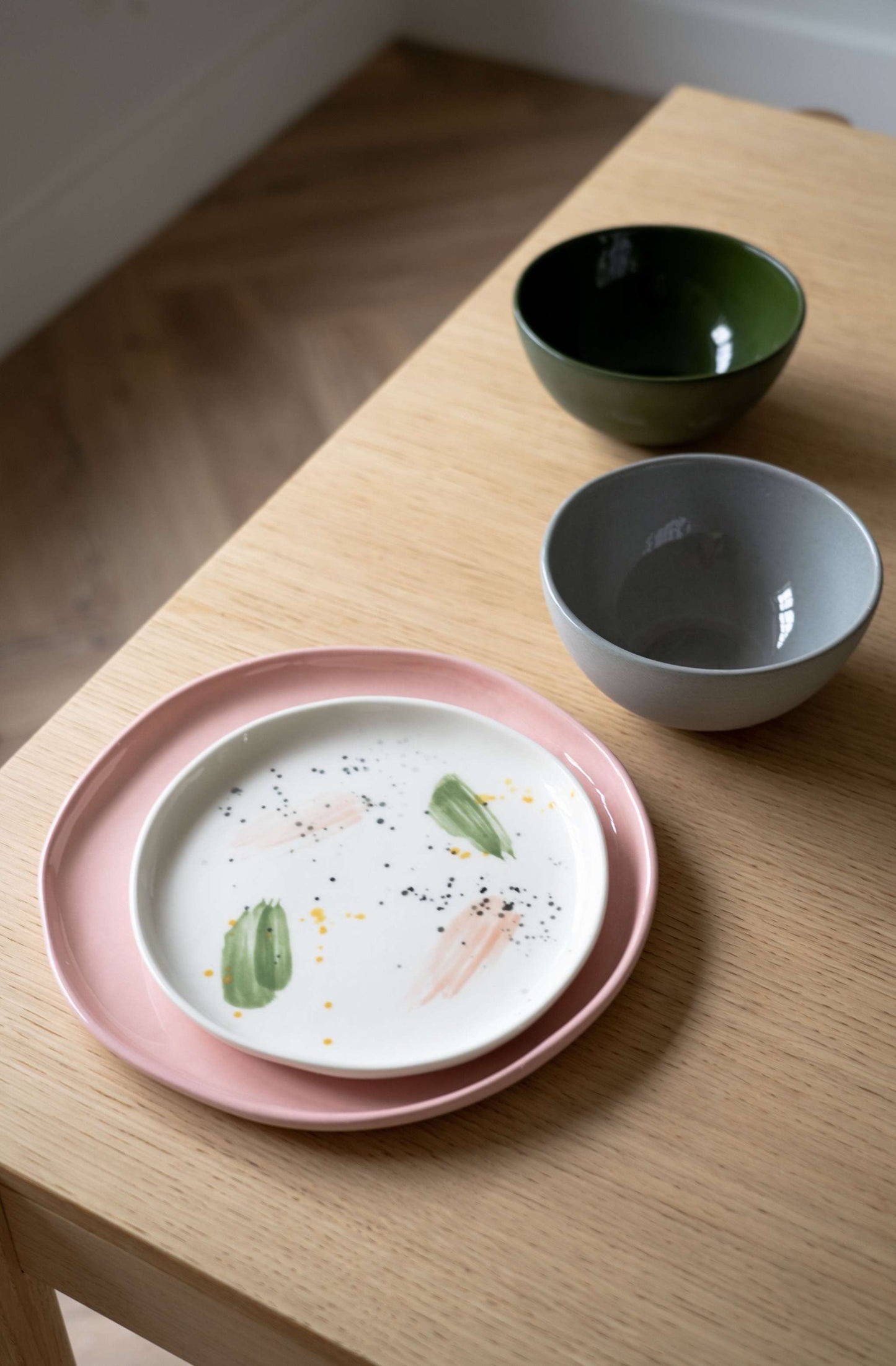 Off-white handmade porcelain dinner plate with hand-painted strokes, glossy finish, and simple elegant design