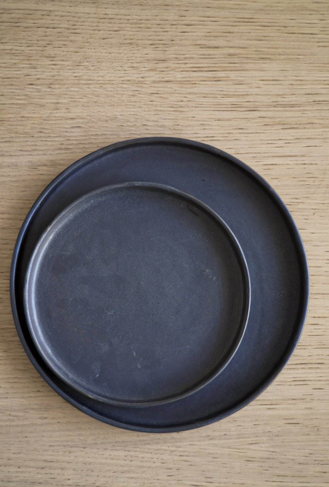 Handmade black matte stoneware dinner plate with textured glaze and organic sides, dishwasher and microwave safe.