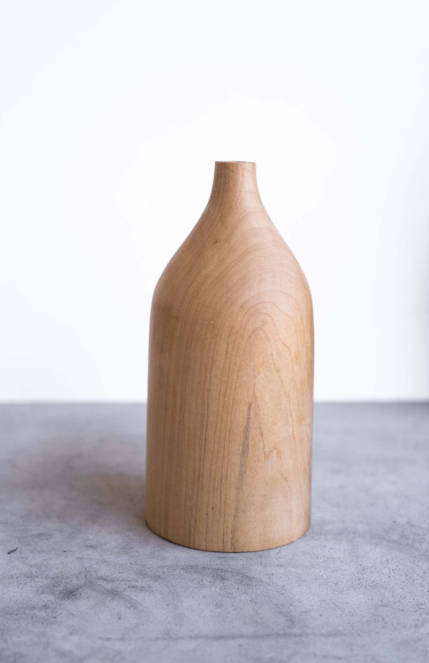 Handcrafted pear wood bottle-shaped vase with natural grain and smooth finish, elegant home decor piece