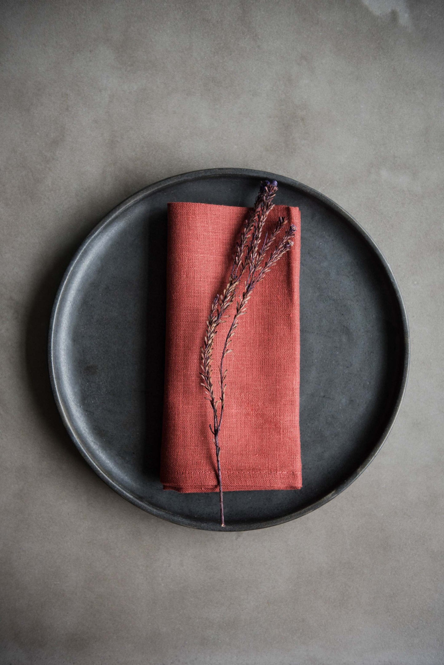 Set of four stonewashed organic linen napkins in black, sand, copper, and cream with straight hems, made in Ukraine.
