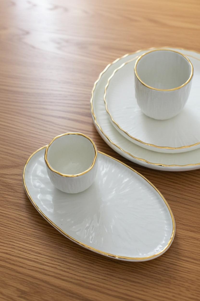 Handmade white porcelain coffee cup with gold rim and hand-carved relief design