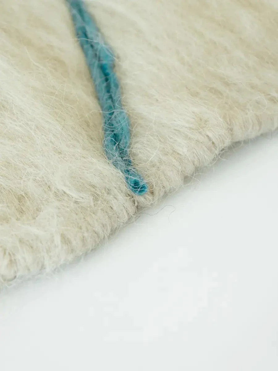 Handwoven wool runner rug with creamy floral design and brushed texture