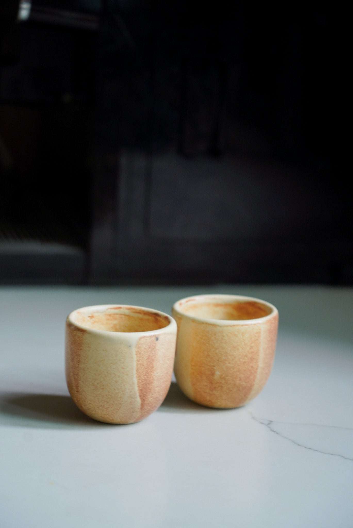 Beige stoneware espresso coffee cup with unique reactive glaze and organic edges, handmade in Ukraine.