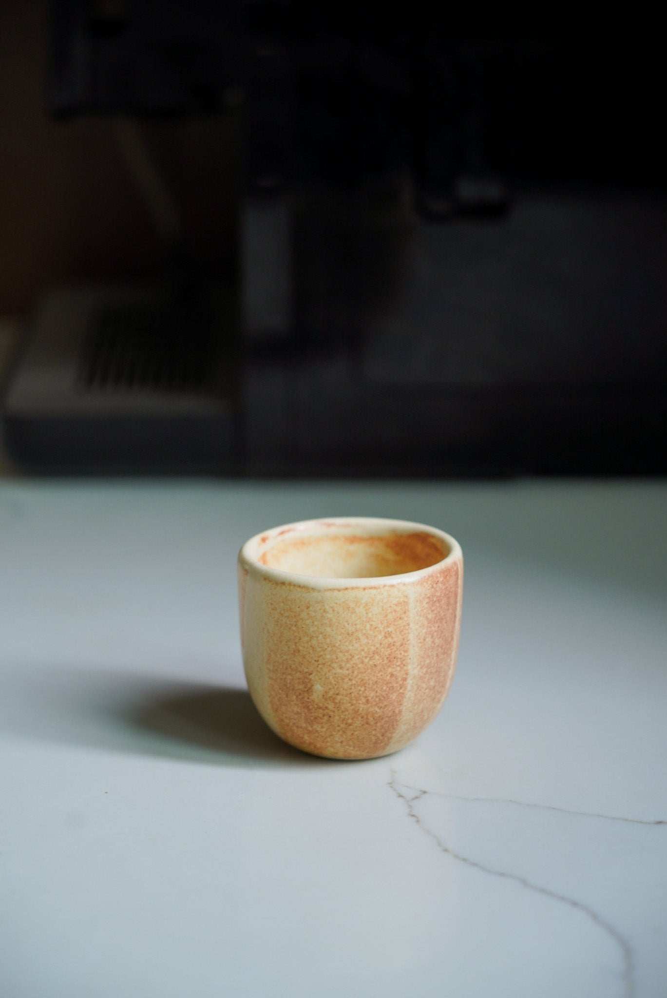 Beige stoneware espresso coffee cup with organic edges and reactive glaze, handmade in Ukraine.